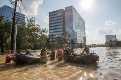 People in hip-deep muddy water in the middle of a city street during a flood. (Image by U.S. Department of Agriculture | Flickr)