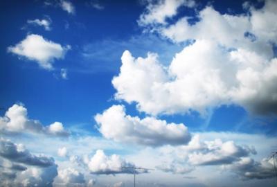 Photograph of fluffy clouds in a bright blue sky. (Photo by icon0.com | Pexels)