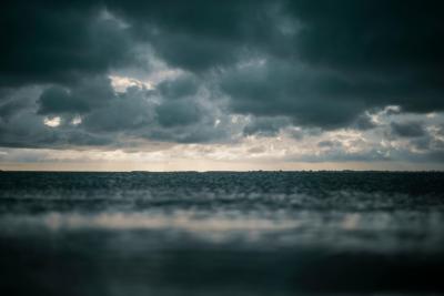 photo of the open ocean with rain falling