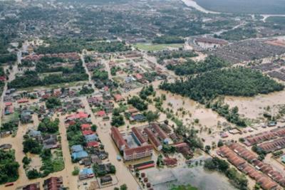 aerial image of a flooded river whose banks are heavily developed with homes and businesses