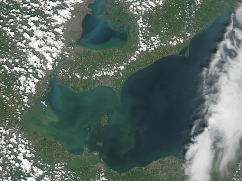 An August 2014 NASA satellite image of the western end of Lake Erie shows milky-green phytoplankton and algae blooms in the coastal waters of Ohio, Michigan, and southwestern Ontario. Such blooms are largely caused by nutrients running off farmlands and can lead to issues such as water-supply shutdowns. This part of the Great Lakes is a study area for the Coastal Observations, Mechanisms, and Predictions Across Systems and Scales (COMPASS) project.